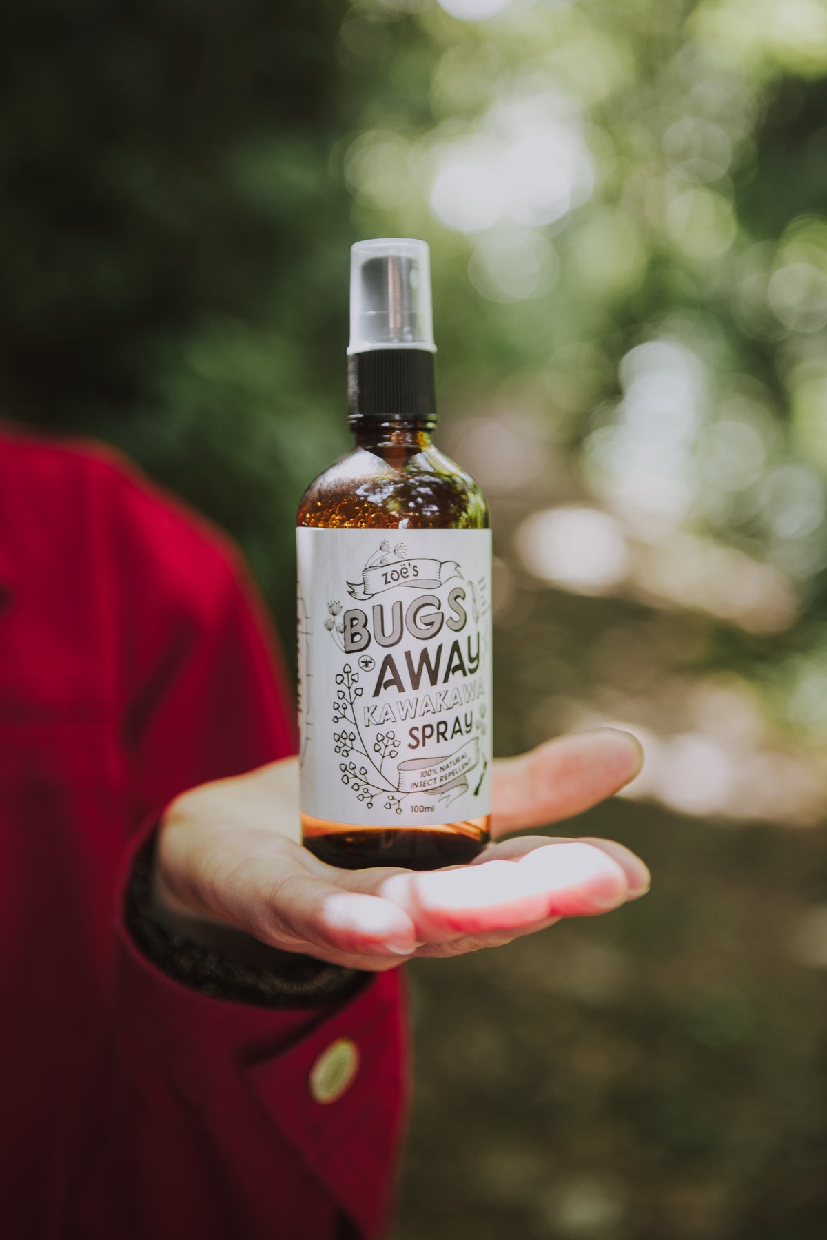 Green Kawakawa leaves surrounding a 100ml Zoe's Bugs Away Kawakawa Spray natural insect repellent